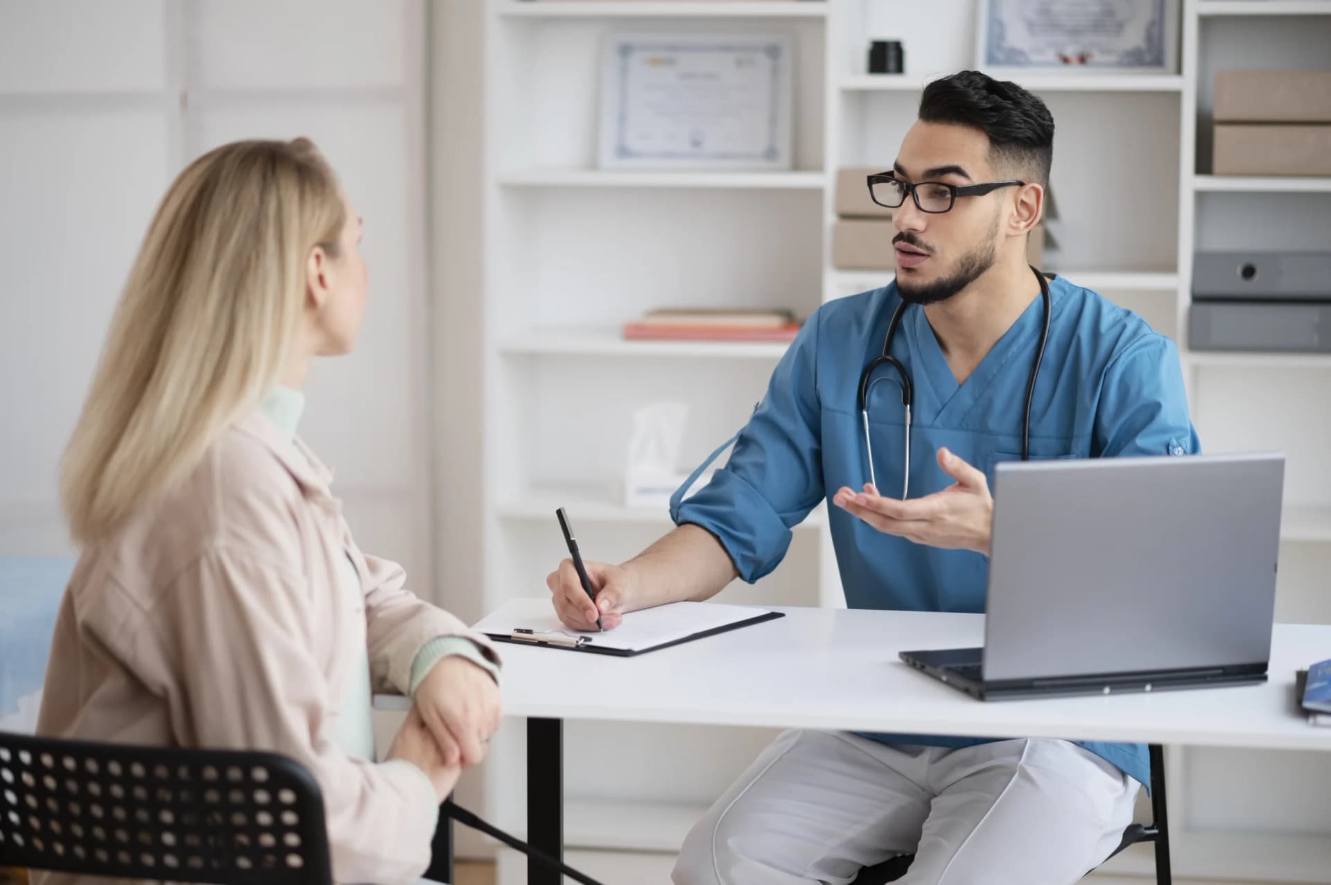 Doctor smiling while reviewing results with a patient across a desk.