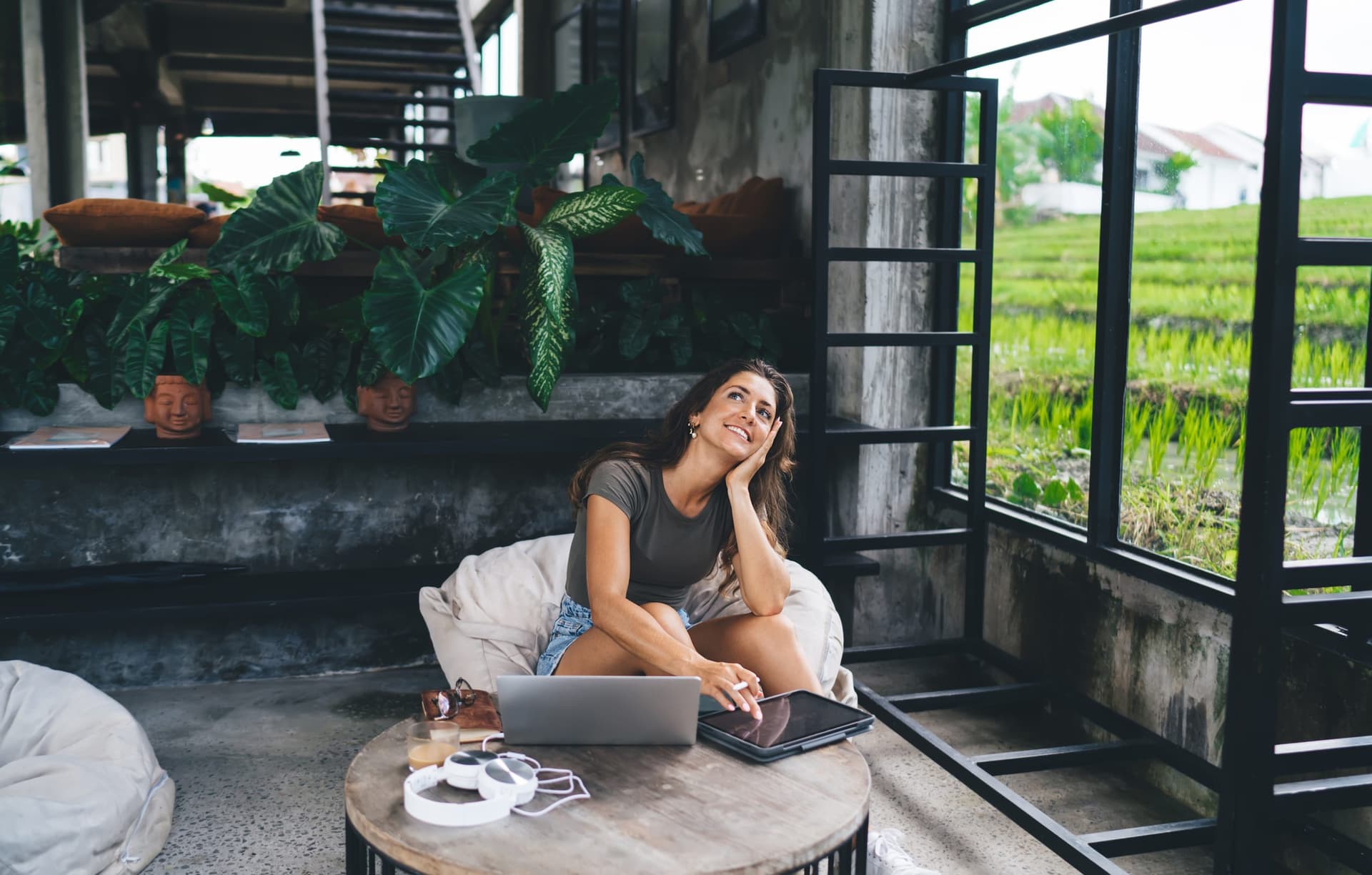 Woman smiling at a cafe table, feeling calm and at ease.