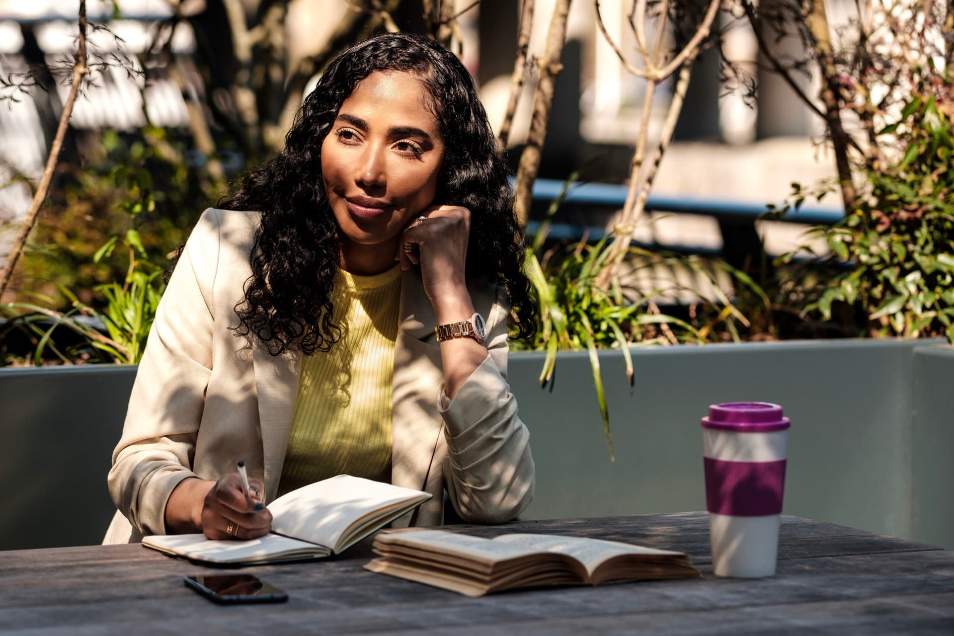 Pensive young woman studying with a notebook and books.