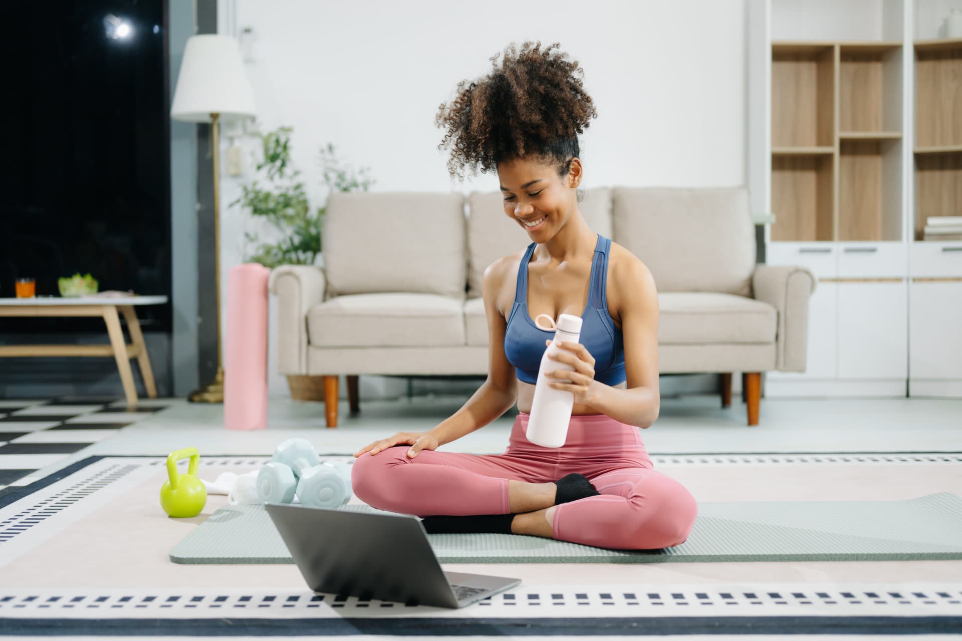 Woman practicing yoga at home while following an online tutorial.