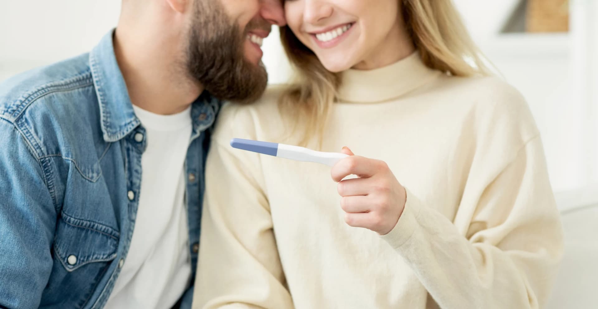 Woman surprising her husband with a positive pregnancy test.