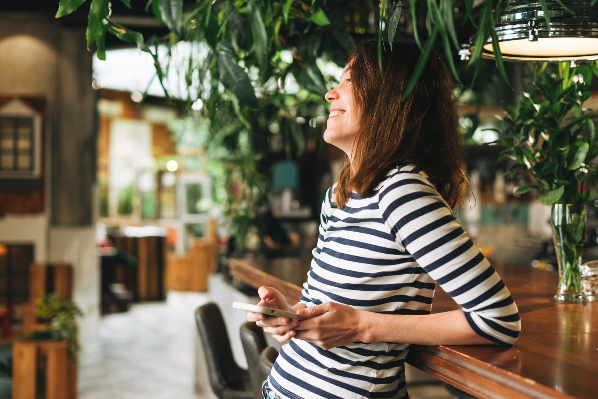 Young woman in casual clothes relaxing at home with her phone.