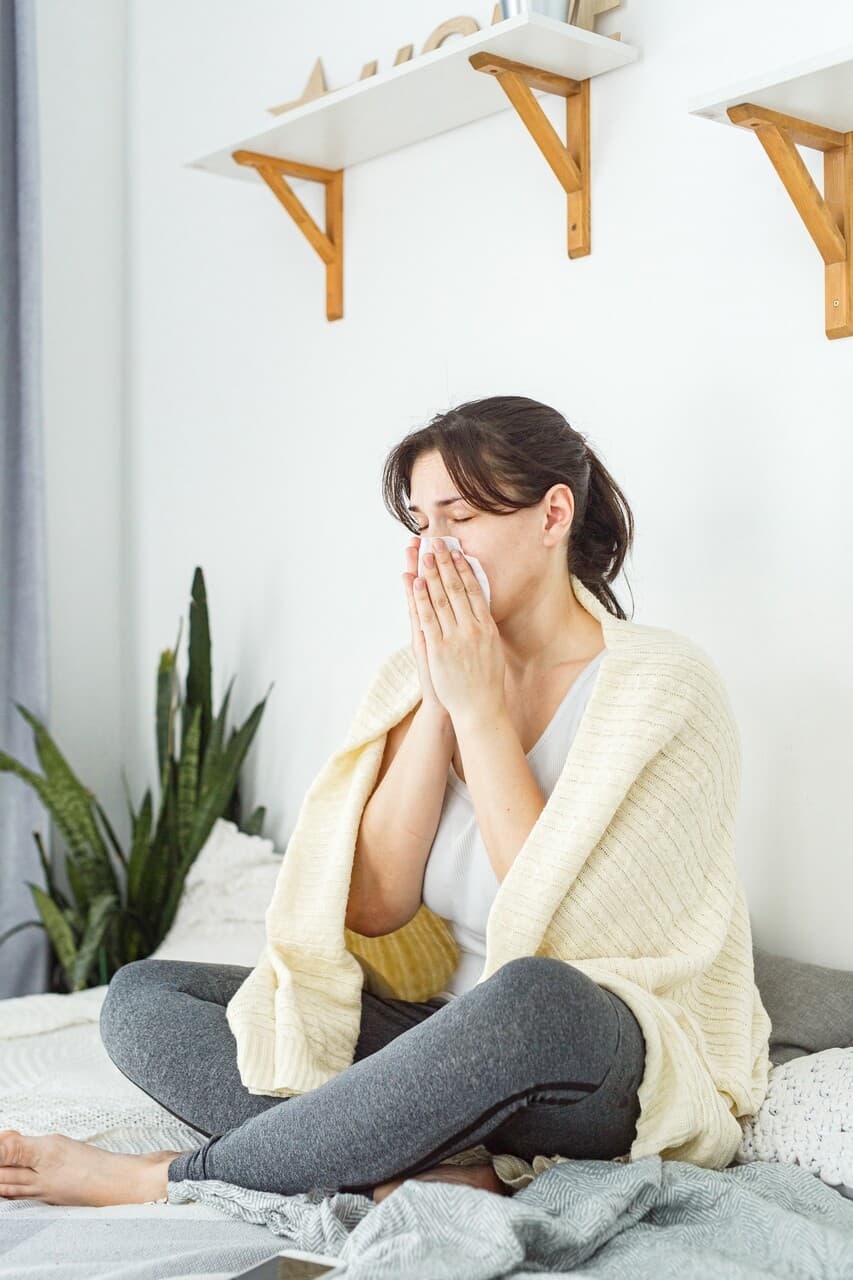 Woman looking fatigued and unwell, possibly experiencing hormone imbalance from mold exposure