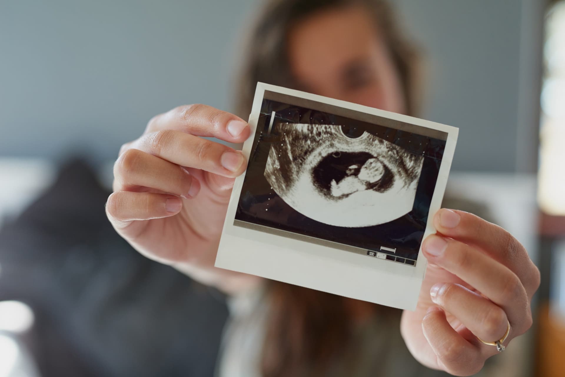 Look at my little peanut. Shot of a woman holding a sonogram of her unborn baby