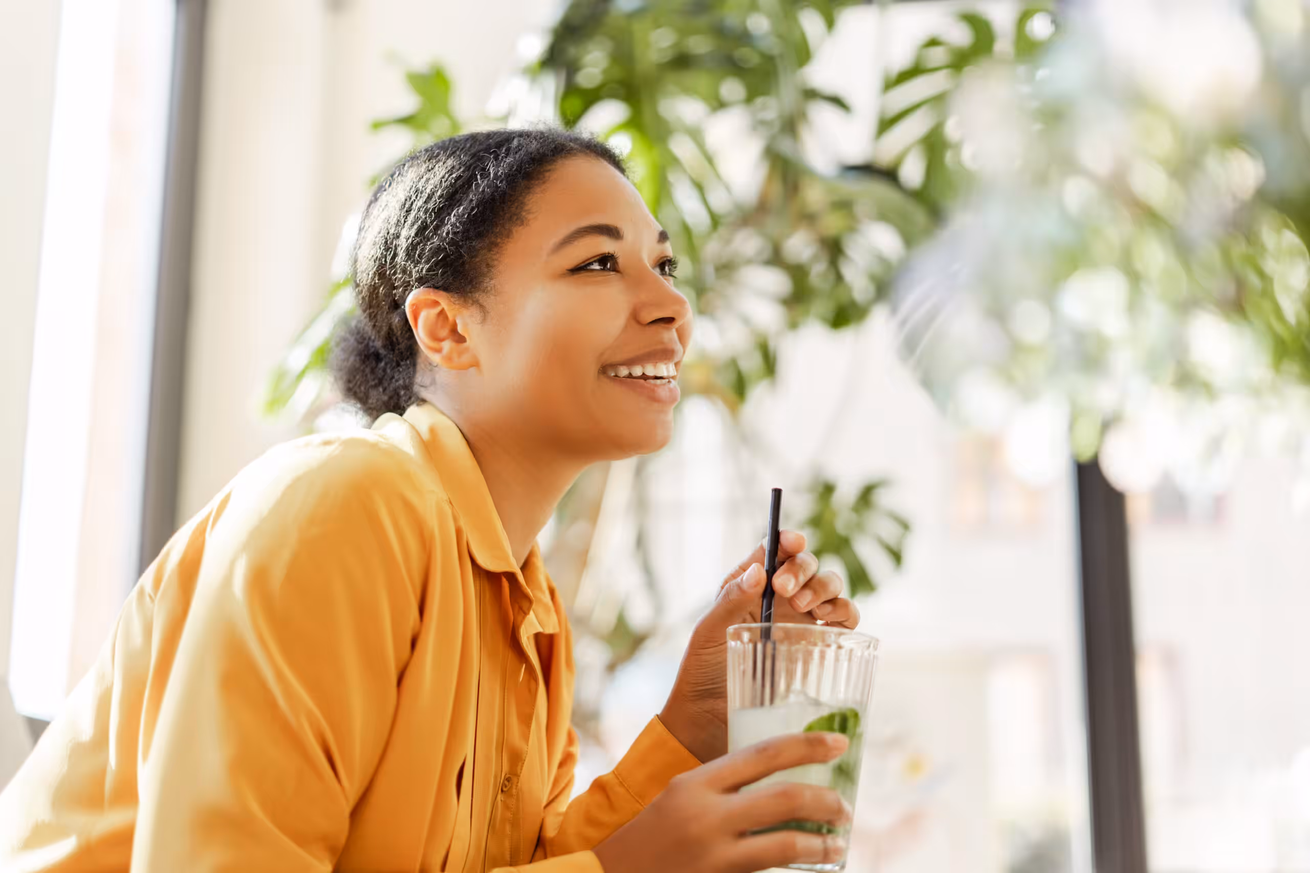 Portrait of smiling beautiful African American woman holding fresh tasty lemonade