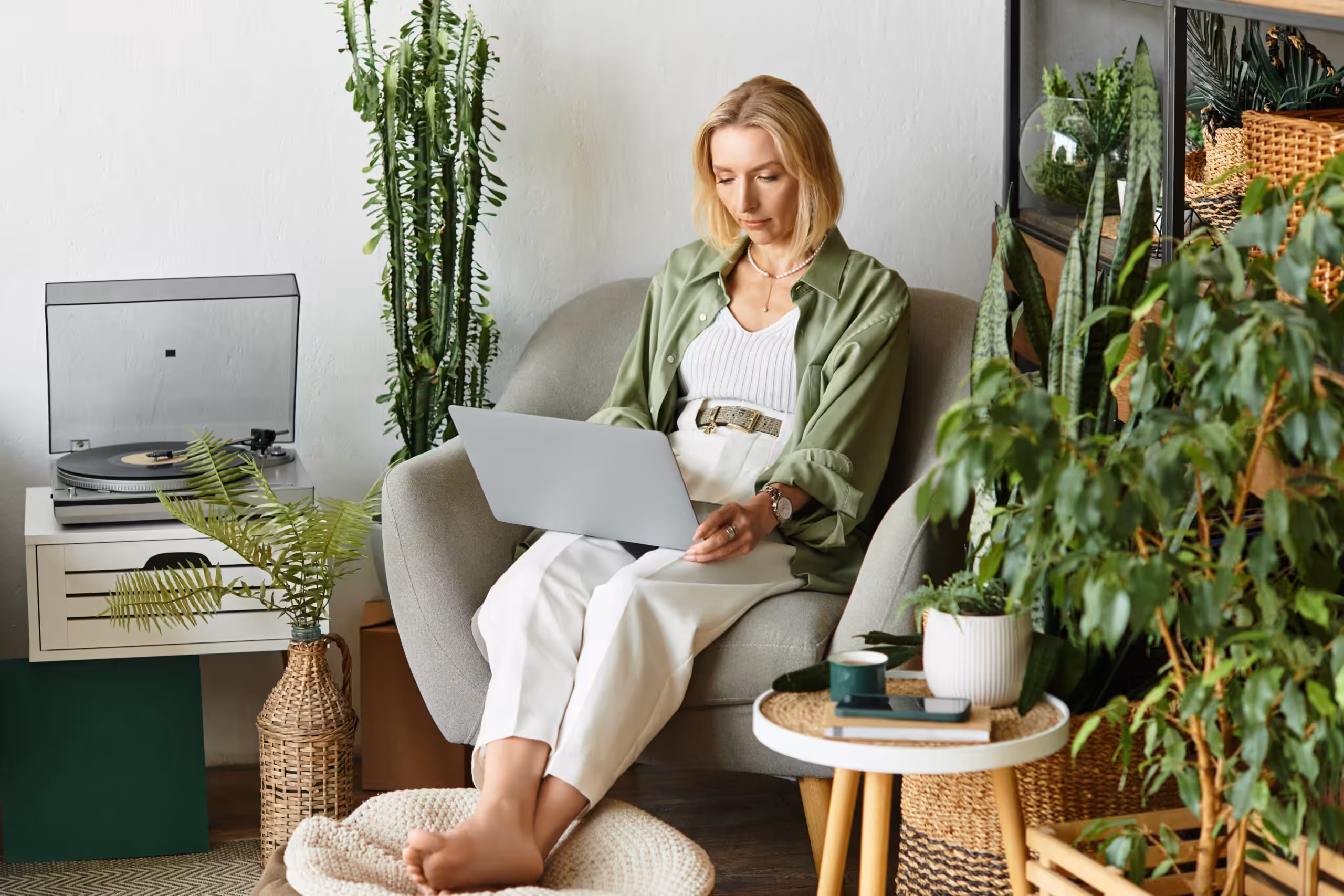 In a cozy home setting, a woman dressed casually sits comfortably while using her laptop.